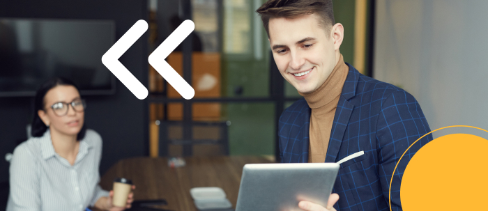 Egresados del posgrado en marketing en modalidad virtual revisan campañas en tablet desde oficina.​