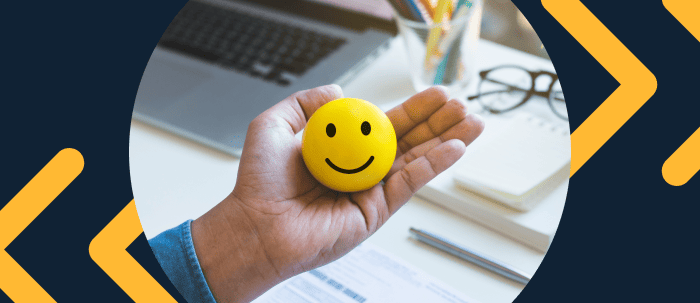 Hombre sostiene una pelota amarilla con carita feliz