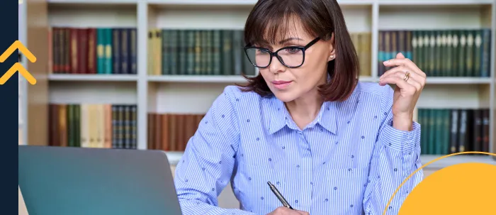 Futura docente estudia con su laptop y cuaderno para prepararse para el examen de idoneidad docente