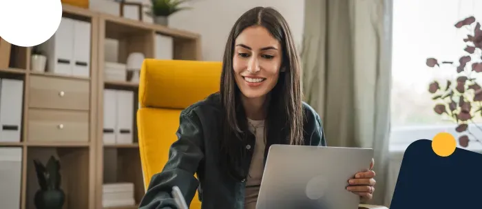 Profesional en economía revisa datos económicos en su laptop mientras sonríe